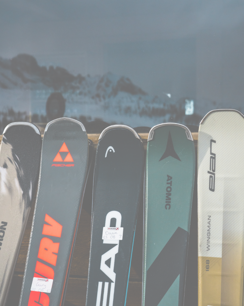 Various branded skis displayed in shop window for Ski Higher.